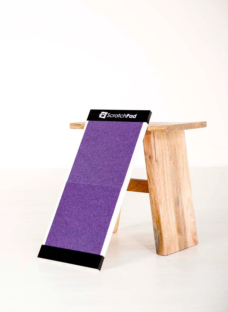 A wooden cat scratching post with a purple scratching surface, branded "ScratchPad," set against a plain background.