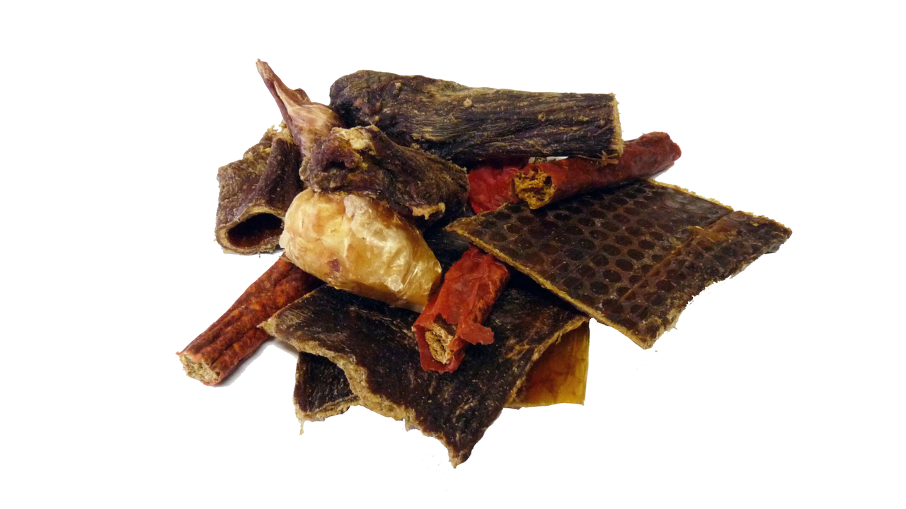 A bag of Superior Pet Food Co. Ranchmans Mixed Treats and Chews, featuring an assortment of strips, rolls, and chunks, rests invitingly on a white background.