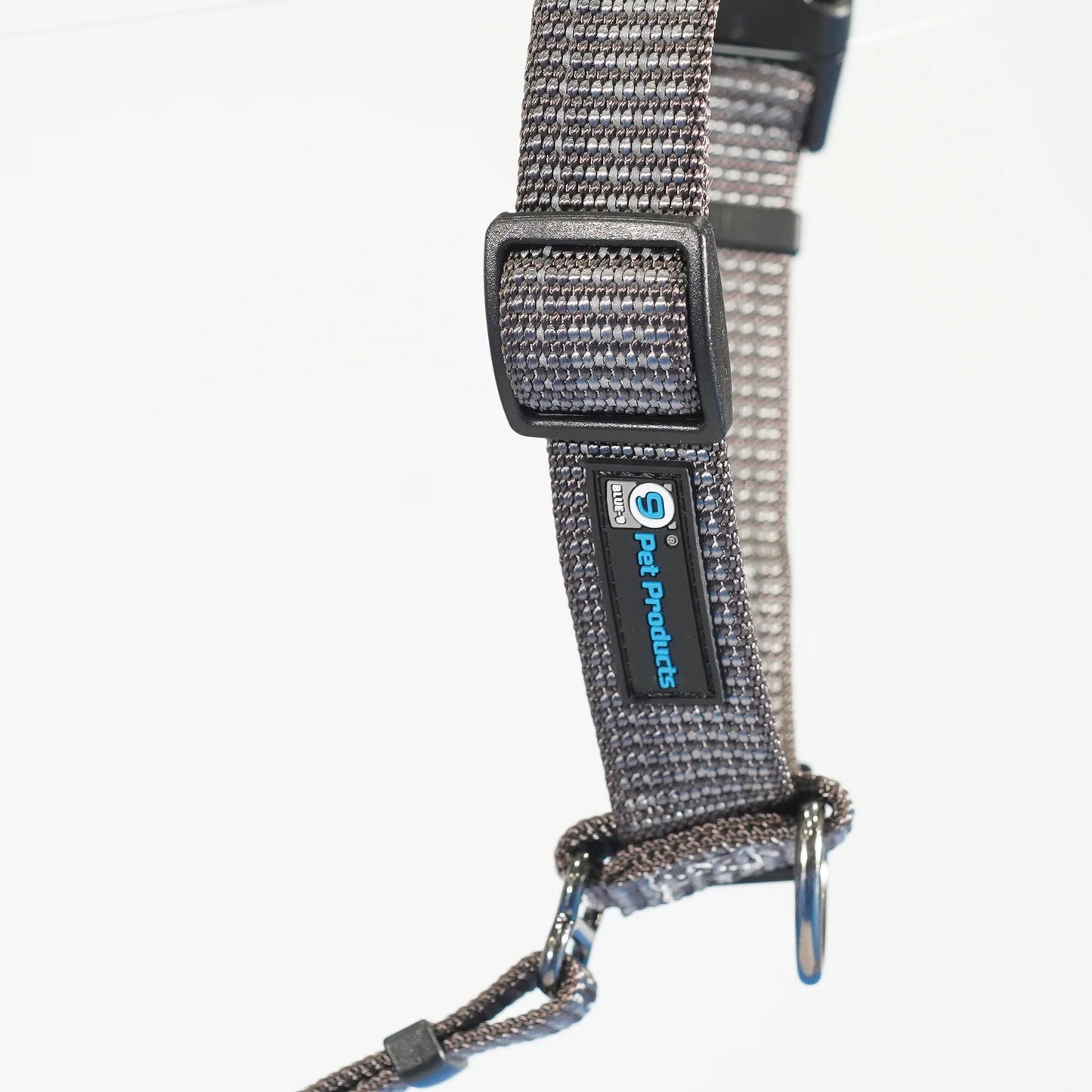 A close-up of the Blue-9 REFLECTIVE Balance Harness shows a gray adjustable design with black buckles and a blue "Blue-9" logo. Made from lightweight nylon, it ensures comfort and safety for your pet during nighttime walks. Available for pre-order.