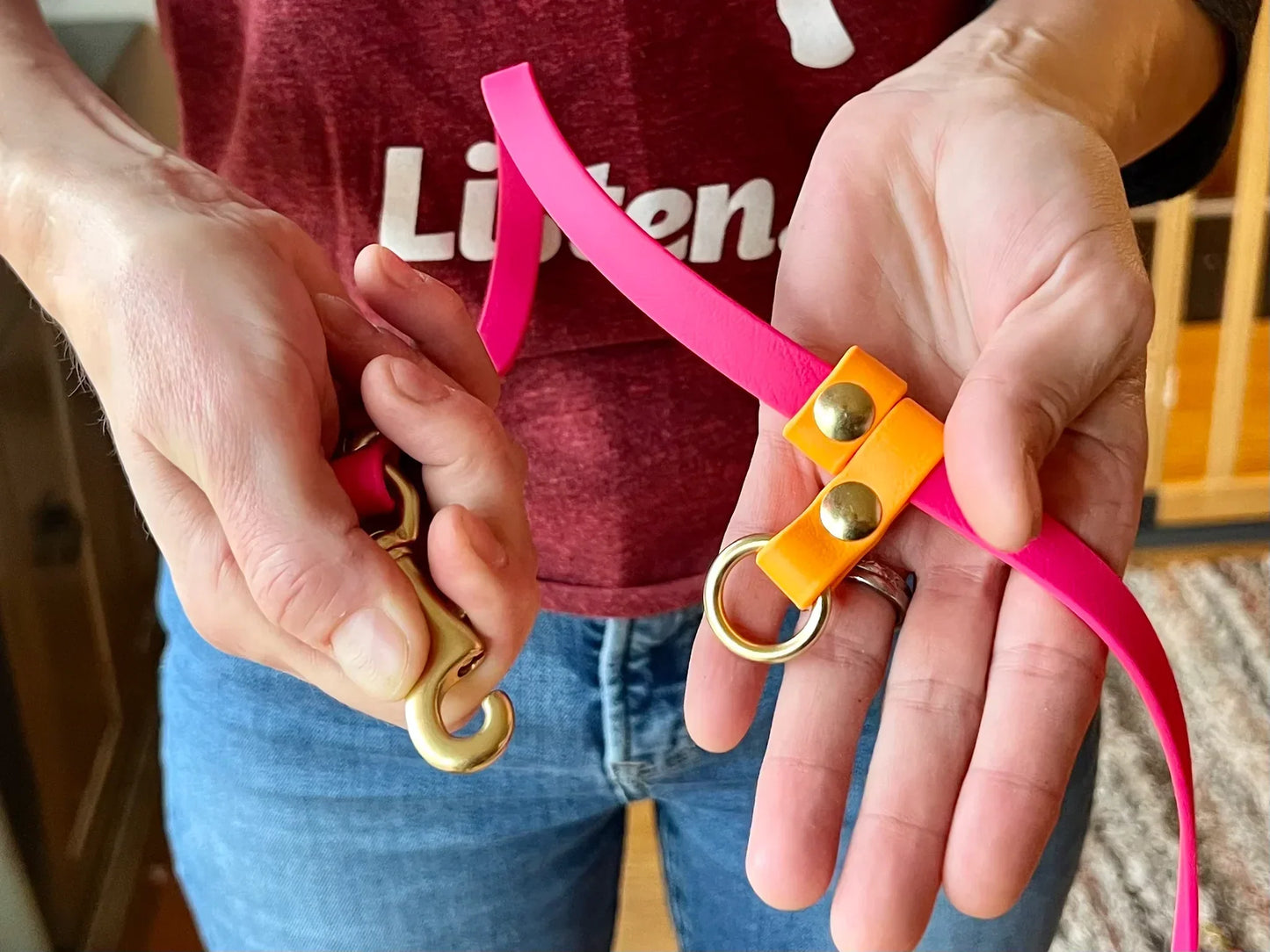 A person holding a Trailblazing Tails: The Shadow Long Line with SLIDE TAB HANDLE - PRE-ORDER in pink and orange.