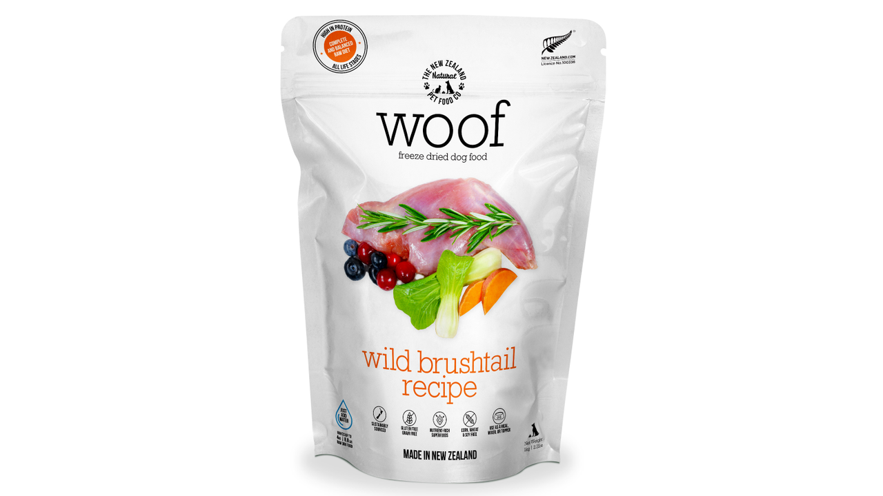 A white package of WOOF - The NZ Natural Petfood Co WOOF Freeze Dried Wild Brushtail Dog Food, grain-free, with images of raw meat, berries, and vegetables on the front.