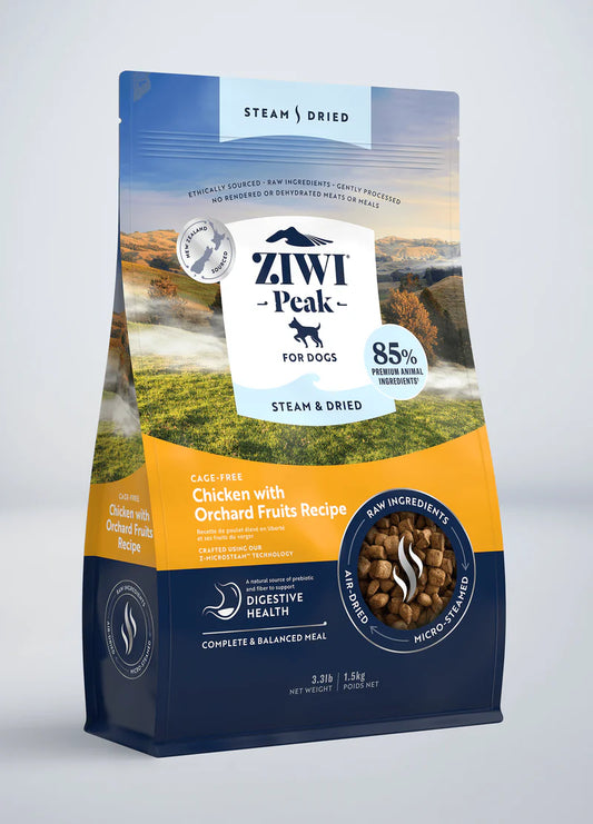 The packaging of ZIWI Peak Steam & Dried Chicken with Orchard Fruits Recipe for Dogs features a mountain landscape image, highlights digestive health benefits, and showcases its 85% animal ingredient content using steam-dried, ethically-sourced raw chicken and orchard fruits.