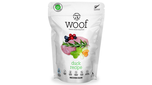 A resealable white bag of WOOF Freeze Dried Duck Dog Food by WOOF - The NZ Natural Petfood Co, showing duck, berries, greens, and “Made in New Zealand,” promotes raw nutrition with natural ingredients.