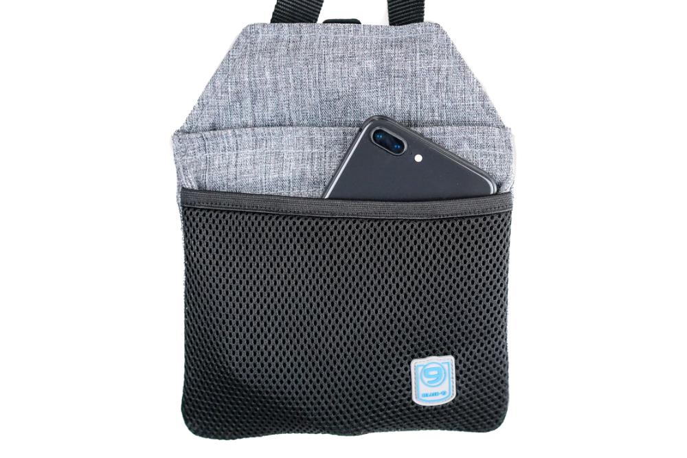A smartphone partially tucked into a black mesh pouch with a gray fabric top, echoing the design of the Blue-9 INSPIRE Training Treat Pouch by Blue-9, showcases a small blue square logo at the bottom.