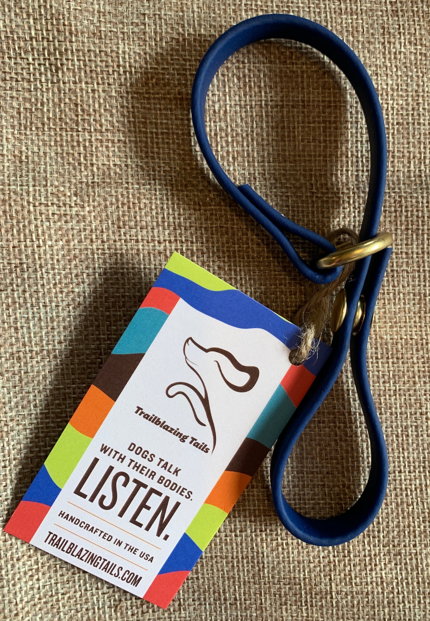 A Trailblazing Tails: The Long Line Holder with a cinch snap and a blue leash featuring a tag that says "listen" by Your Whole Dog.