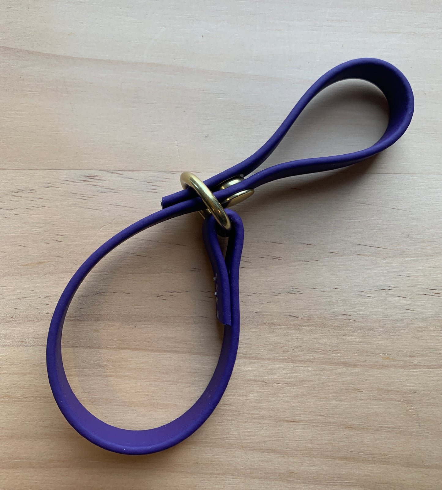 A Trailblazing Tails: The Long Line Holder dog leash cinched to a wooden table. Brand: Your Whole Dog.