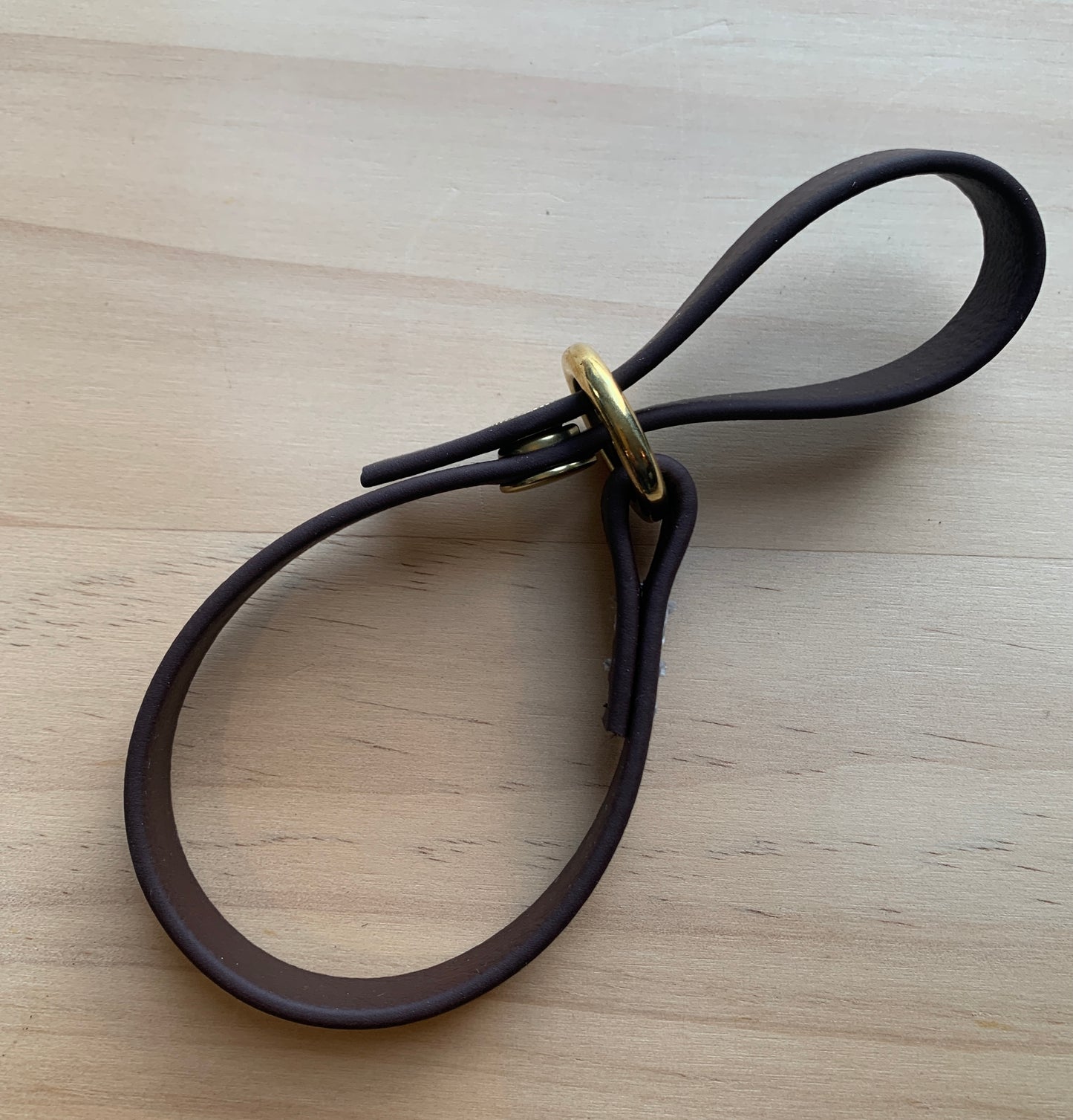 A Trailblazing Tails: The Long Line Holder with a snap on a wooden table.