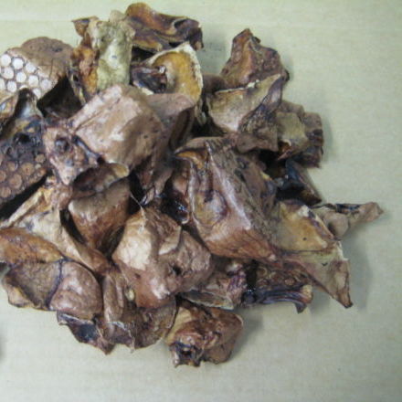A pile of dried, crumpled mushroom pieces on a beige surface resembles Superior Pet Food Co.'s Ranchmans Lamb Marshmallow Bites (Lamb Lung), making them perfect as natural dog treats.