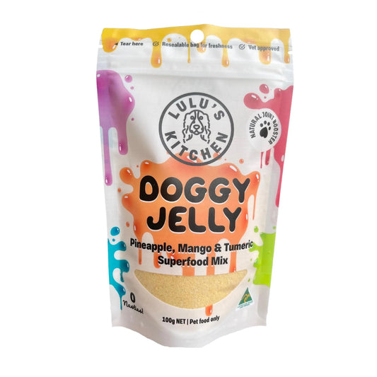 A 100g pack of Lulu's Kitchen Doggy Jelly features pineapple, mango, and turmeric flavors. The packaging has colorful splashes and is clearly labeled as pet food only.