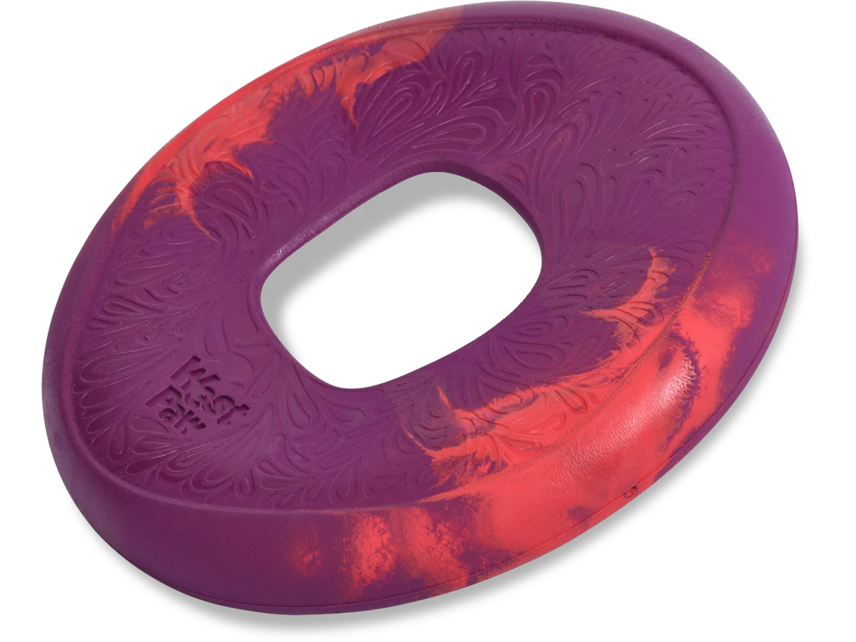 The West Paw Sailz by West Paw is a red and purple rubber ring with a textured surface and an oval center, ideal for playful dogs.