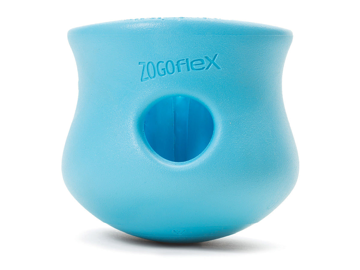 The West Paw Toppl is a durable blue rubber dog toy with a hole in the center, ideal for stuffing treats. Labeled "Zogoflex," this enrichment toy offers endless fun.