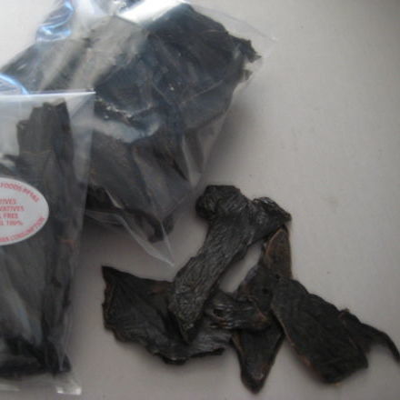 Superior Pet Food Co. (Ranchmans) Beef Liver pieces scattered on a surface, with additional pieces packed in a clear plastic bag, highlight their natural essence.