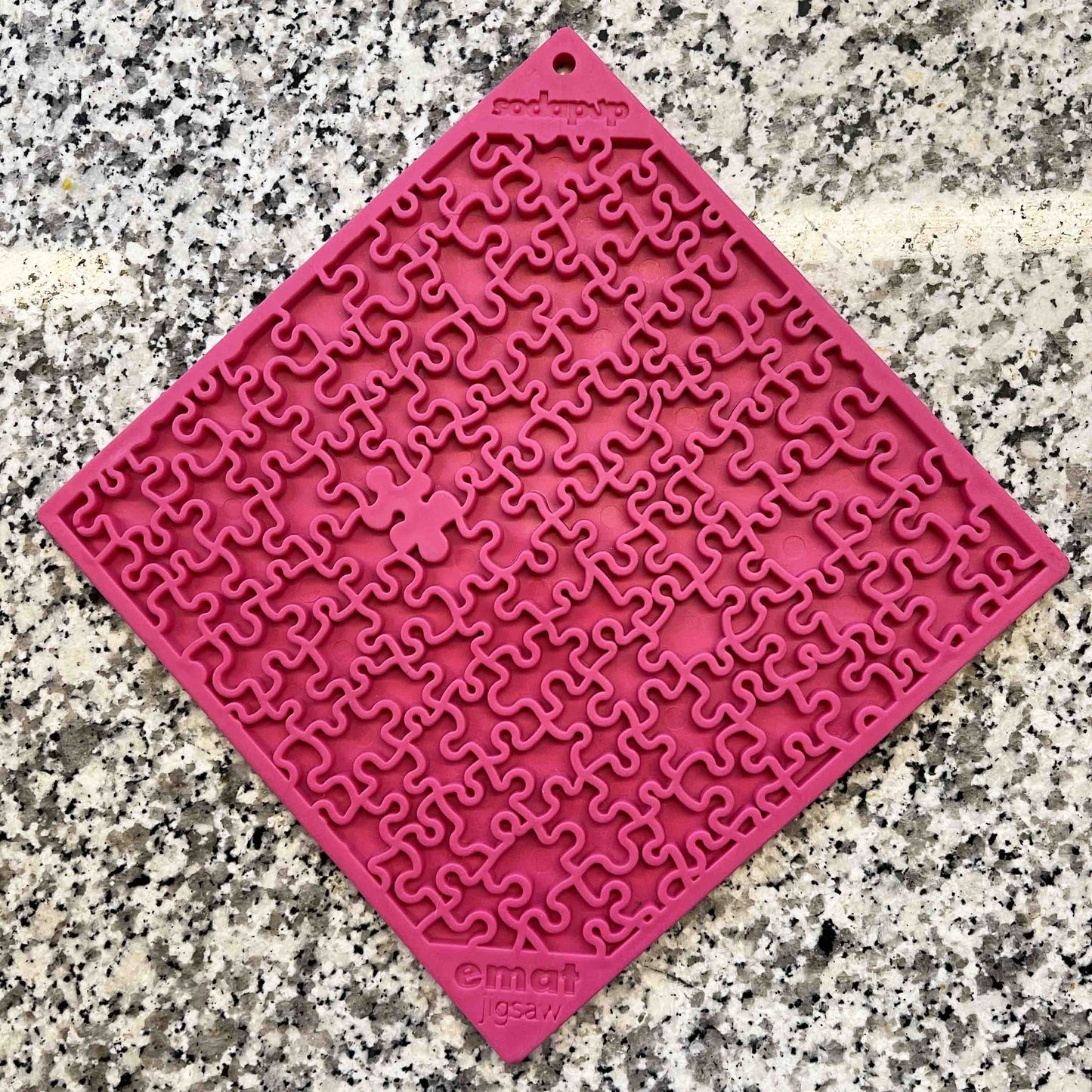 The clearance Soda Pup EMAT Enrichment Licking Mat, resembling a red jigsaw puzzle with a central missing piece on granite, captures the excitement of dog foraging activities.