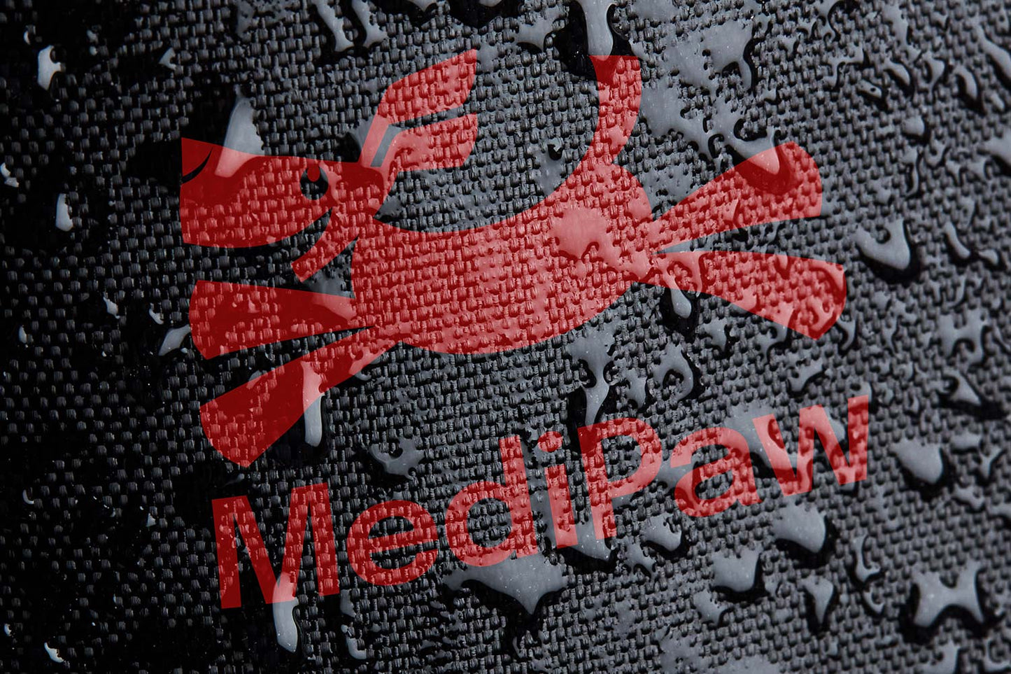 A close-up showcases the red, stylized dog logo and the word "MediPaw" on a textured black surface adorned with water droplets, reflecting the durability of the MediPaw Soft Bandage (Basic) Boot by Your Whole Dog, which features a waterproof nylon shell and soft bandage boot design.