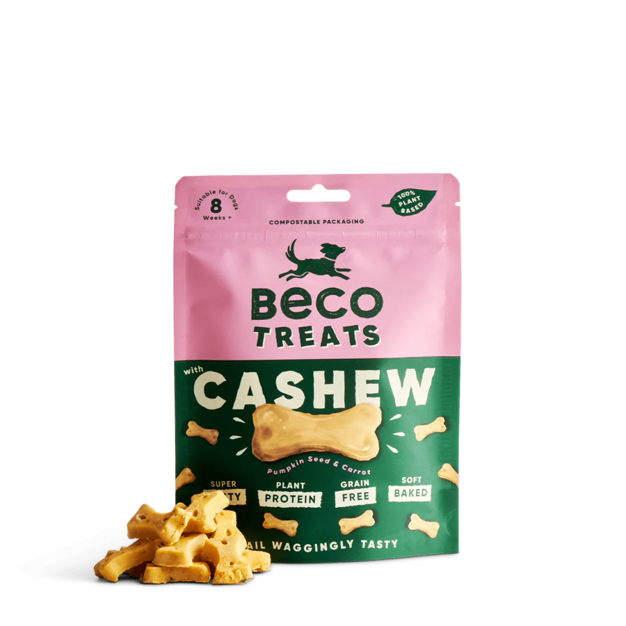 A pink and green bag of Your Whole Dog Beco Pets Cashew Dog Treats with Pumpkin Seed & Carrot, featuring bone-shaped, soft-baked, plant-based and grain-free dog treats in front.