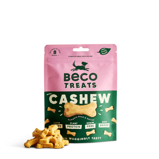 A pink and green bag of Your Whole Dog Beco Pets Cashew Dog Treats with Pumpkin Seed & Carrot, featuring bone-shaped, soft-baked, plant-based and grain-free dog treats in front.