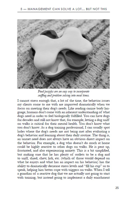 A page from "Manage It! Hacks for Improving Your Dog’s Behavior" by Juliana De Willems (Your Whole Dog) covers food puzzles and dog behavior management, with a photo showing a food puzzle toy and a caption on sniffing and problem solving.