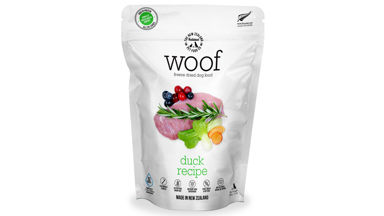 A bag of Your Whole Dog's Woof: Freeze Dried Duck Dog Food with a variety of raw fruits and vegetables.