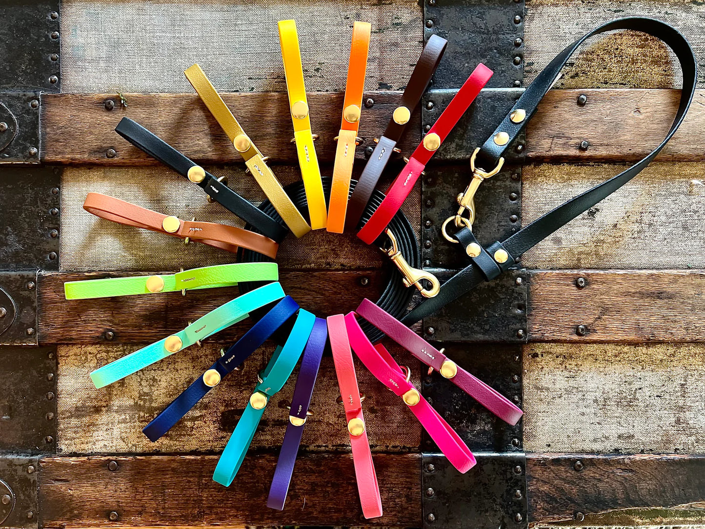A group of colorful leather leashes laid on top of a wooden crate, perfect for the Trailblazing Tails: The Long Line Holder enthusiast or Your Whole Dog connoisseur.