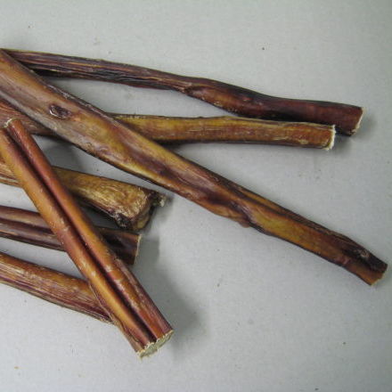 A bundle of Superior Pet Food Co (Ranchmans) Beef Pizzle Sticks (15cm) on a white surface at Your Whole Dog..
