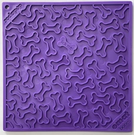 The Soda Pup EMAT Licking Mat on clearance is a vibrant purple silicone mat with embossed bone shapes and "lick me!" at the center, ideal for enhancing dog foraging activities.