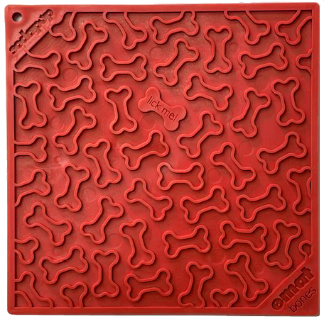 Red pet lick mat with bone-shaped grooves, perfect for enrichment and promoting dog health. Small center section labeled "lick me." Brand name "Your Whole Dog" printed in the corners.