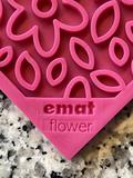 A pink 3D-printed Soda Pup EMAT ENRICHMENT LICKING MAT resembling a flower, labeled "Your Whole Dog" against a speckled background, designed as an enrichment mat for licking.